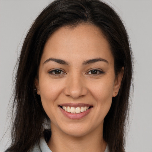 Joyful latino young-adult female with long  brown hair and brown eyes