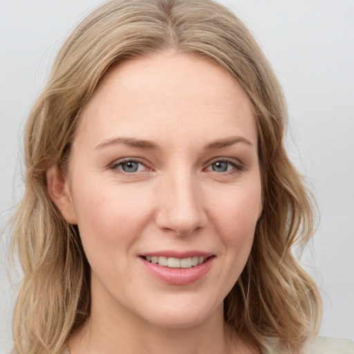 Joyful white young-adult female with long  brown hair and blue eyes