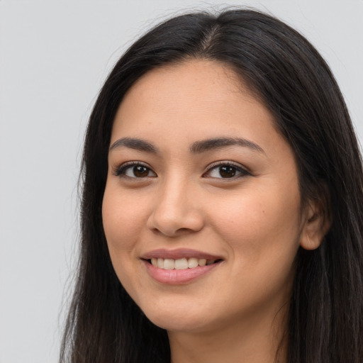 Joyful latino young-adult female with long  brown hair and brown eyes