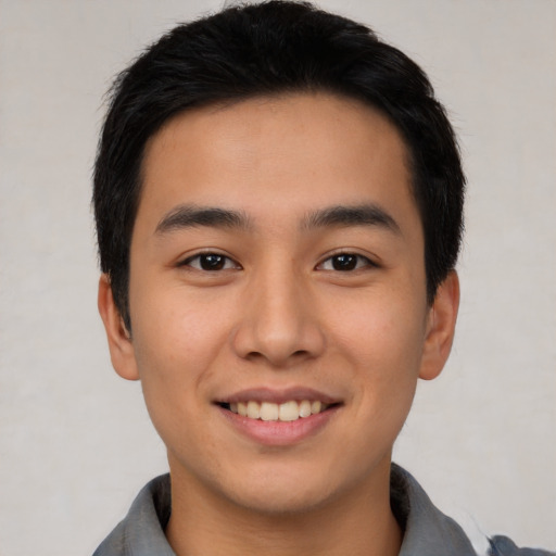 Joyful asian young-adult male with short  black hair and brown eyes