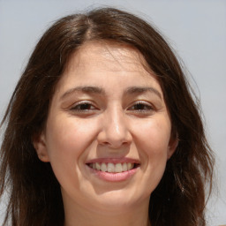 Joyful white adult female with long  brown hair and brown eyes