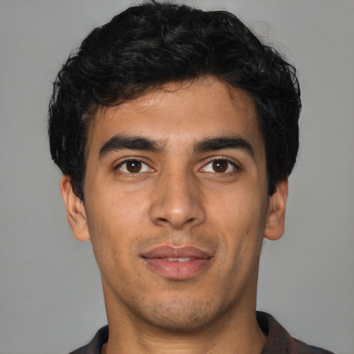 Joyful latino young-adult male with short  black hair and brown eyes