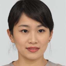 Joyful asian young-adult female with short  brown hair and brown eyes