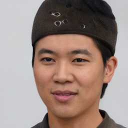 Joyful asian young-adult male with short  black hair and brown eyes