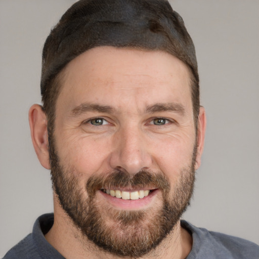 Joyful white adult male with short  brown hair and brown eyes