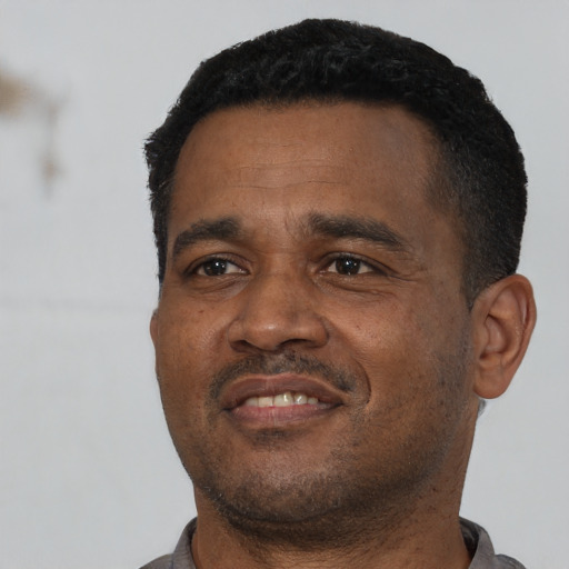 Joyful latino adult male with short  black hair and brown eyes