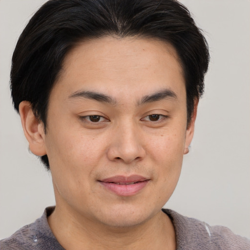 Joyful asian young-adult male with short  brown hair and brown eyes