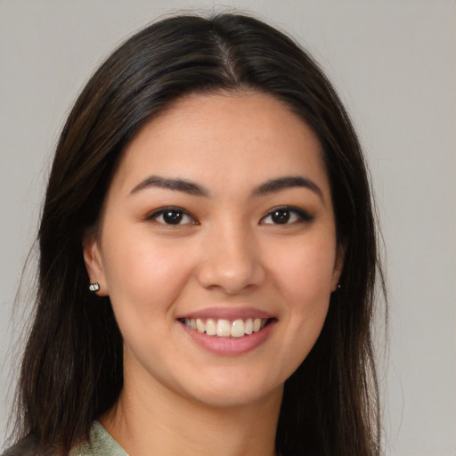 Joyful latino young-adult female with long  brown hair and brown eyes