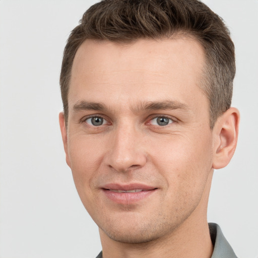 Joyful white young-adult male with short  brown hair and grey eyes