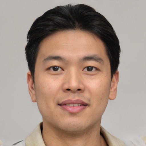 Joyful asian young-adult male with short  brown hair and brown eyes