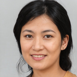 Joyful asian young-adult female with medium  black hair and brown eyes