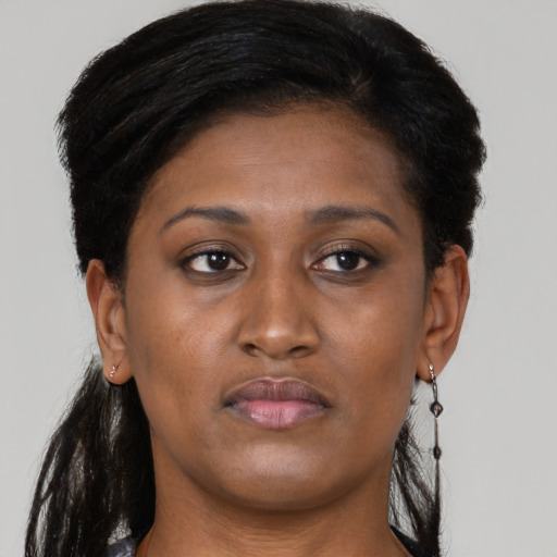 Joyful black adult female with long  brown hair and brown eyes