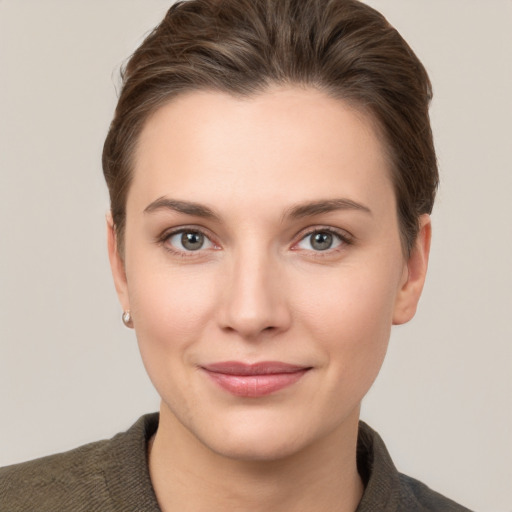 Joyful white young-adult female with short  brown hair and grey eyes