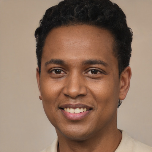 Joyful black young-adult male with short  black hair and brown eyes