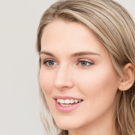 Joyful white young-adult female with long  brown hair and blue eyes