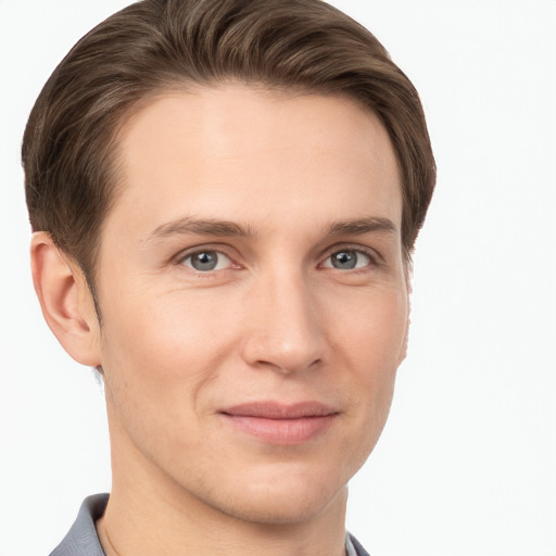 Joyful white young-adult male with short  brown hair and grey eyes