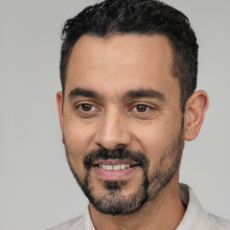 Joyful white adult male with short  black hair and brown eyes