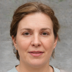 Joyful white adult female with medium  brown hair and grey eyes