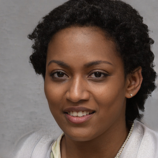 Joyful black young-adult female with short  black hair and brown eyes