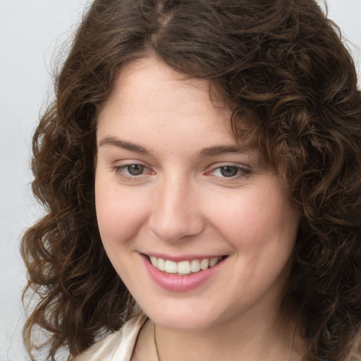 Joyful white young-adult female with medium  brown hair and green eyes