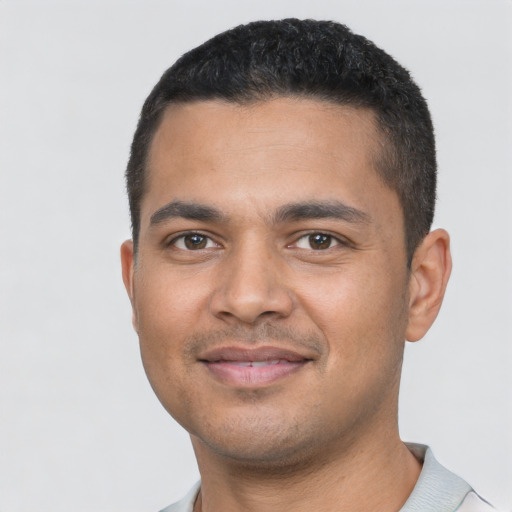 Joyful latino young-adult male with short  black hair and brown eyes