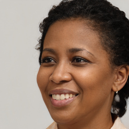 Joyful black young-adult female with short  brown hair and brown eyes