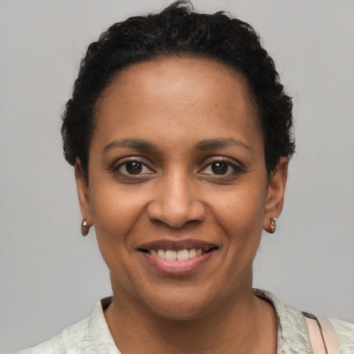 Joyful black young-adult female with short  brown hair and brown eyes
