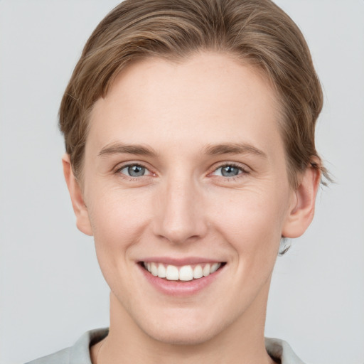 Joyful white young-adult female with short  brown hair and grey eyes