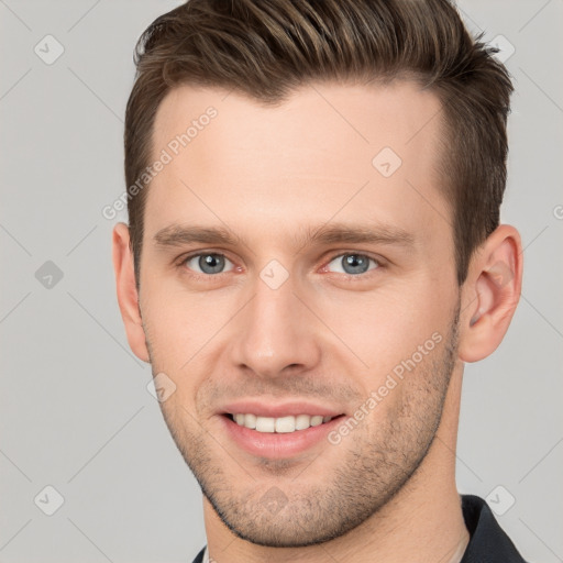 Joyful white young-adult male with short  brown hair and grey eyes