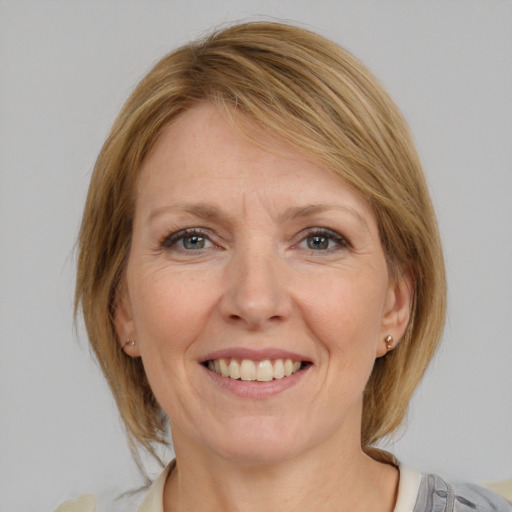 Joyful white adult female with medium  brown hair and blue eyes