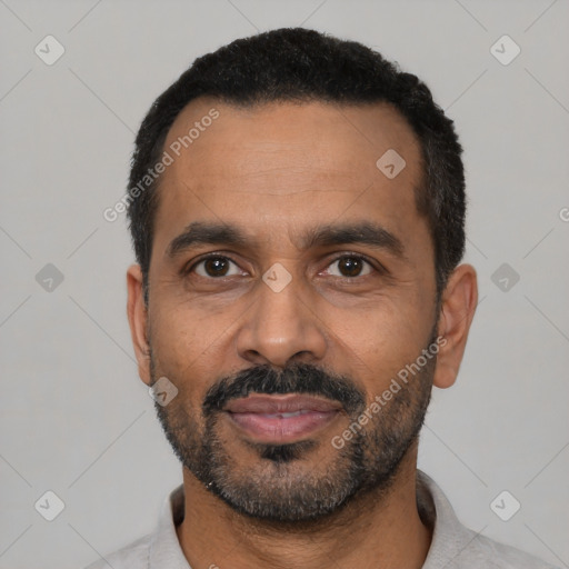 Joyful black adult male with short  black hair and brown eyes