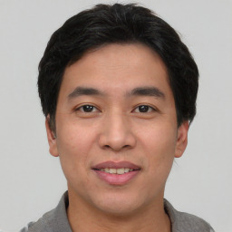 Joyful asian young-adult male with short  black hair and brown eyes