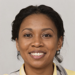 Joyful black adult female with medium  brown hair and brown eyes