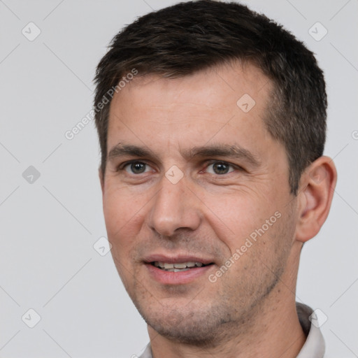 Joyful white adult male with short  black hair and brown eyes