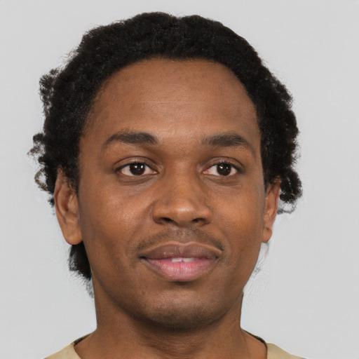Joyful black young-adult male with short  brown hair and brown eyes
