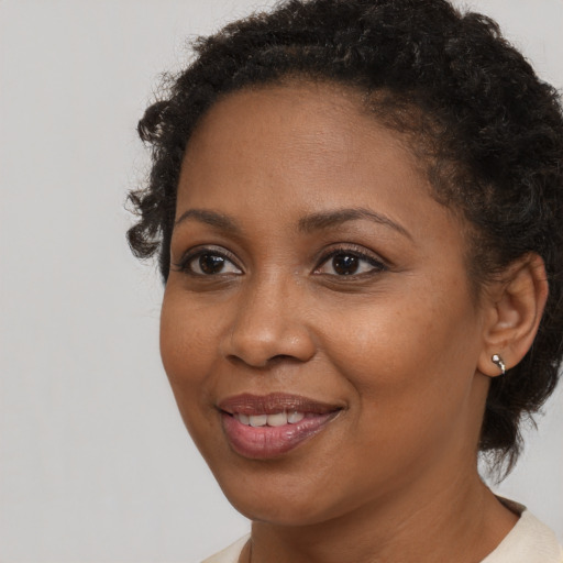 Joyful black adult female with short  brown hair and brown eyes