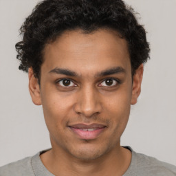 Joyful latino young-adult male with short  brown hair and brown eyes