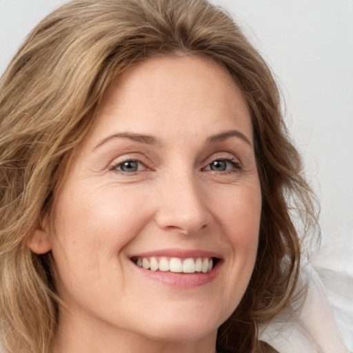 Joyful white young-adult female with medium  brown hair and blue eyes