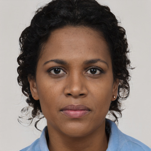 Joyful black young-adult female with long  black hair and brown eyes
