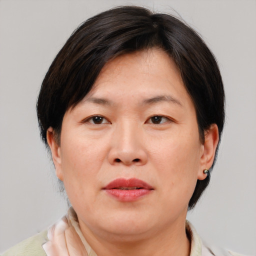 Joyful asian adult female with medium  brown hair and brown eyes