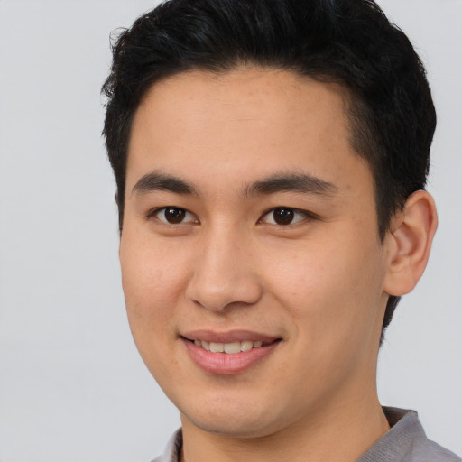 Joyful asian young-adult male with short  brown hair and brown eyes
