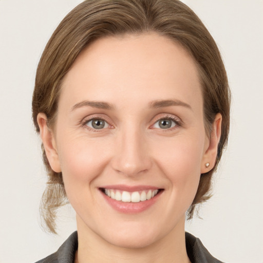 Joyful white young-adult female with medium  brown hair and grey eyes