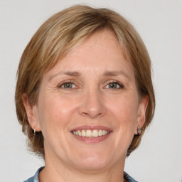 Joyful white adult female with medium  brown hair and grey eyes