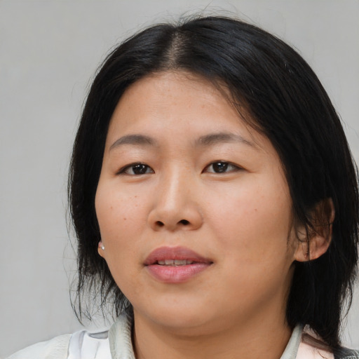 Joyful asian young-adult female with medium  brown hair and brown eyes