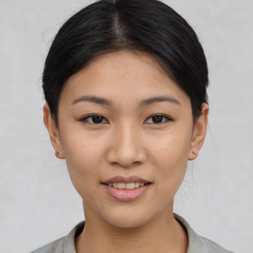 Joyful asian young-adult female with short  black hair and brown eyes