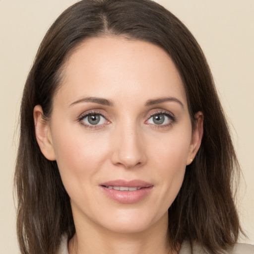 Joyful white young-adult female with medium  brown hair and grey eyes