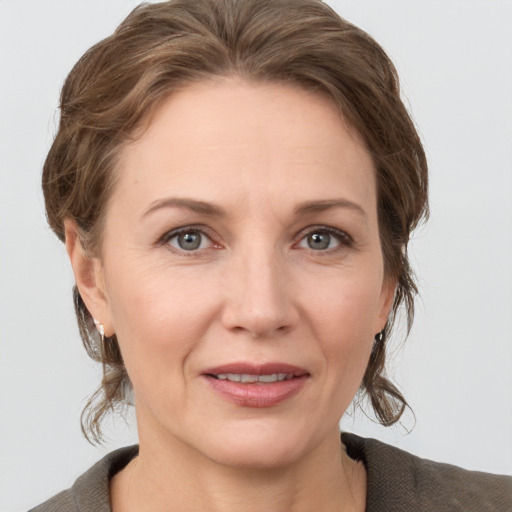 Joyful white adult female with medium  brown hair and grey eyes