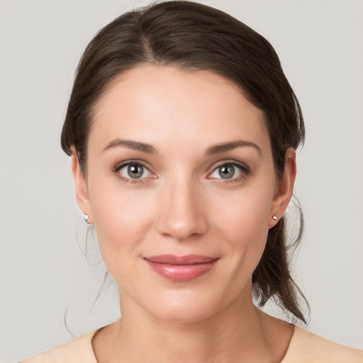 Joyful white young-adult female with medium  brown hair and grey eyes