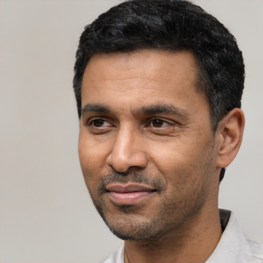 Joyful latino adult male with short  black hair and brown eyes