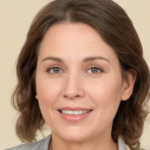 Joyful white adult female with medium  brown hair and grey eyes